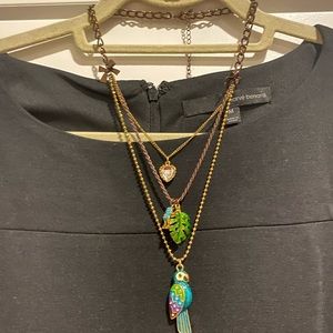 Bronze necklace with 3 chains that include a heart, frog, leaf, and parrot